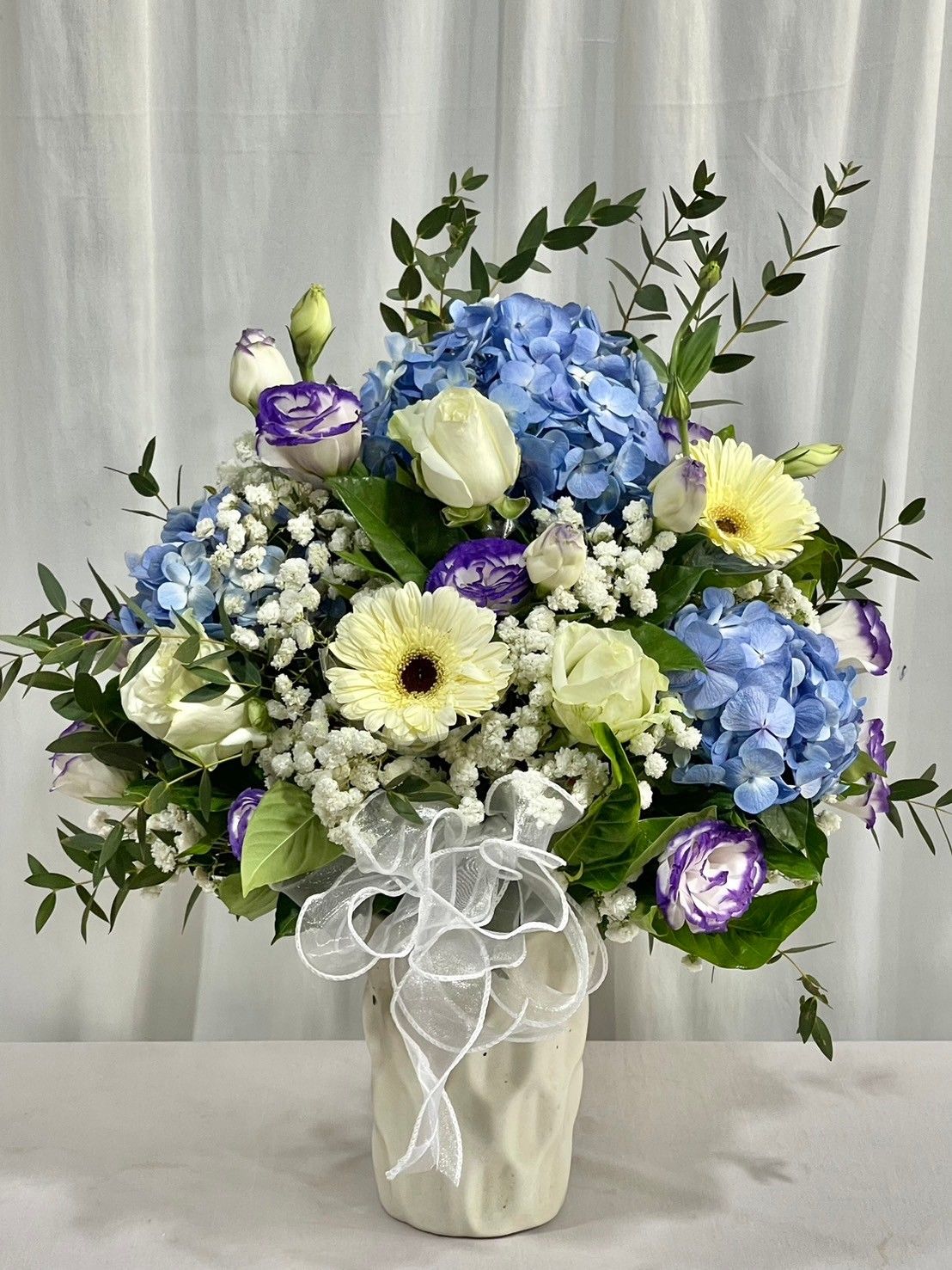 Blue hydrangea with purple flower in vase