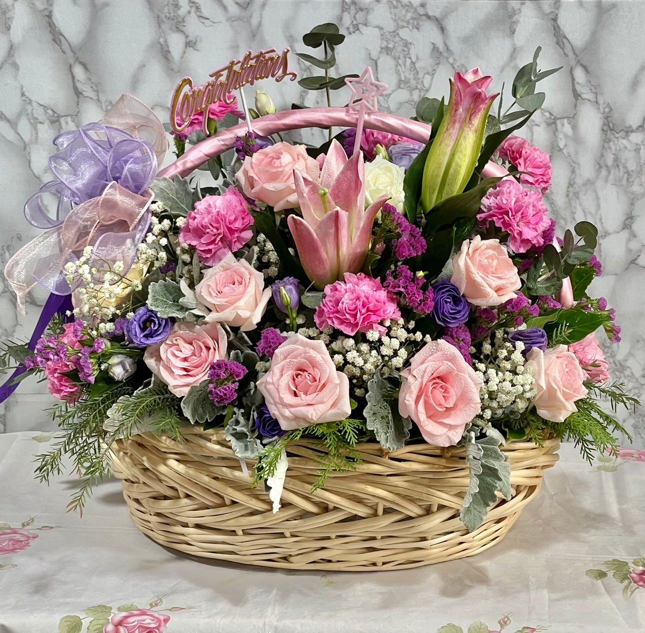 Pink rose and pink lily in white basket