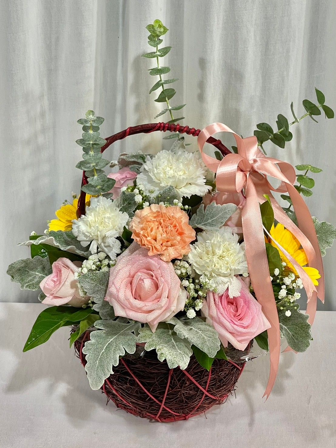 Pink rose and white flower in basket